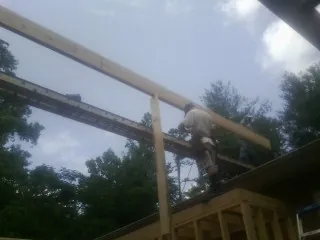 Carpenter setting a ridge beam over a new addition frame — Ice Dam Removal by Roofing Brothers in Orwell