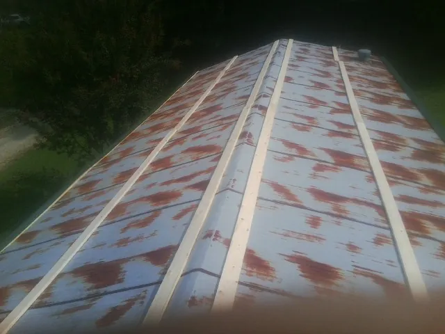 Rusted metal roof panels with new wood purlins before replacement — Storm Damage Roof Repair in Orwell by Roofing Brothers