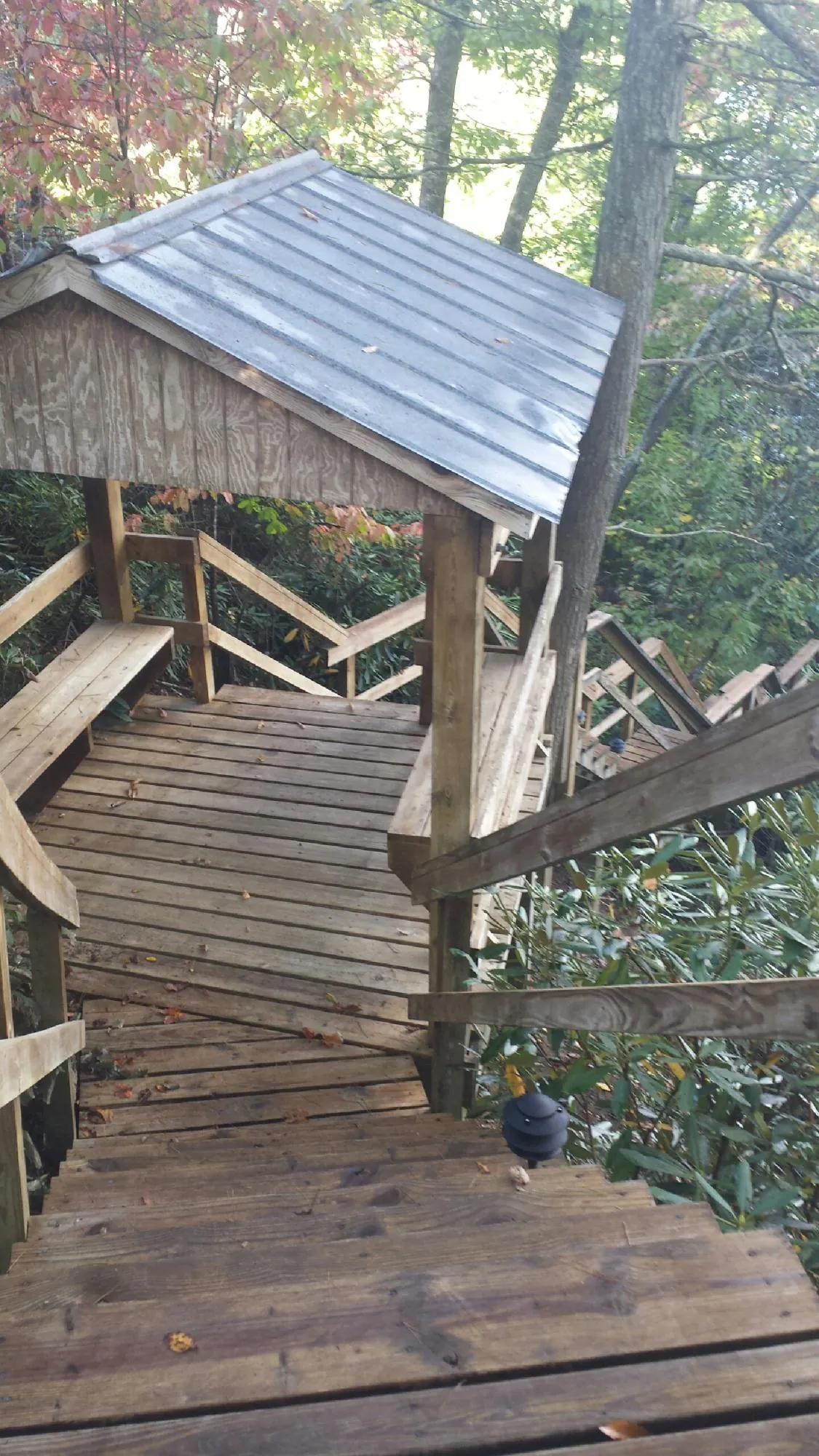 Metal roofed shelter over wooden steps on a wooded walkway — Skylight Repair & Installation work by our crew in Orwell